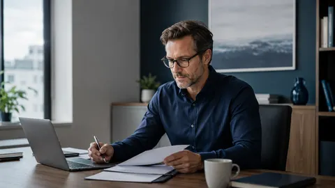 Berufstätige Person prüft an einem modernen Arbeitsplatz Unterlagen zur langfristigen finanziellen Absicherung der eigenen Arbeitskraft.