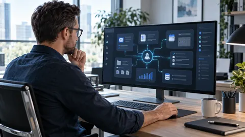 Person an einem modernen Arbeitsplatz betrachtet auf einem Bildschirm miteinander verbundene digitale Arbeitsabläufe für E-Mails, Termine, Dokumente und Aufgaben.